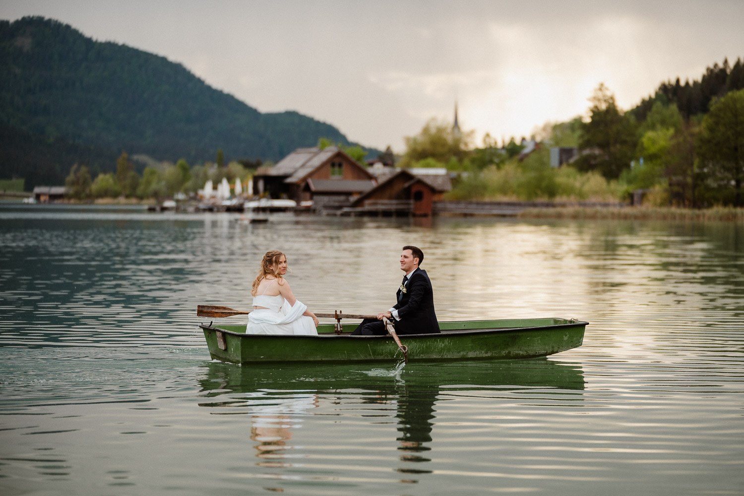 Hochzeitsfoto am Weissensee in Kärnten. Das Brautpaar steht auf einer Wiese über dem See und küsst sich. Aufgenommen von Hochzeitsfotograf Valentino Zippo aus Kärnten. Hochzeit am Weissensee, Hochzeitslocation, Boot, besondere Hochzeitsmomente, Neusacherhof 